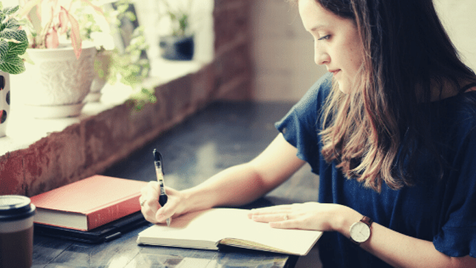 Woman at desk using journal prompts